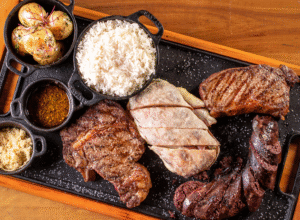 Box Buenos Aires com bife ancho, bife de chorizo e colita de cuadril fatiados na travessa, ao lado de provoleta na chapa, no Ramalho Experience, churrascaria em Campinas