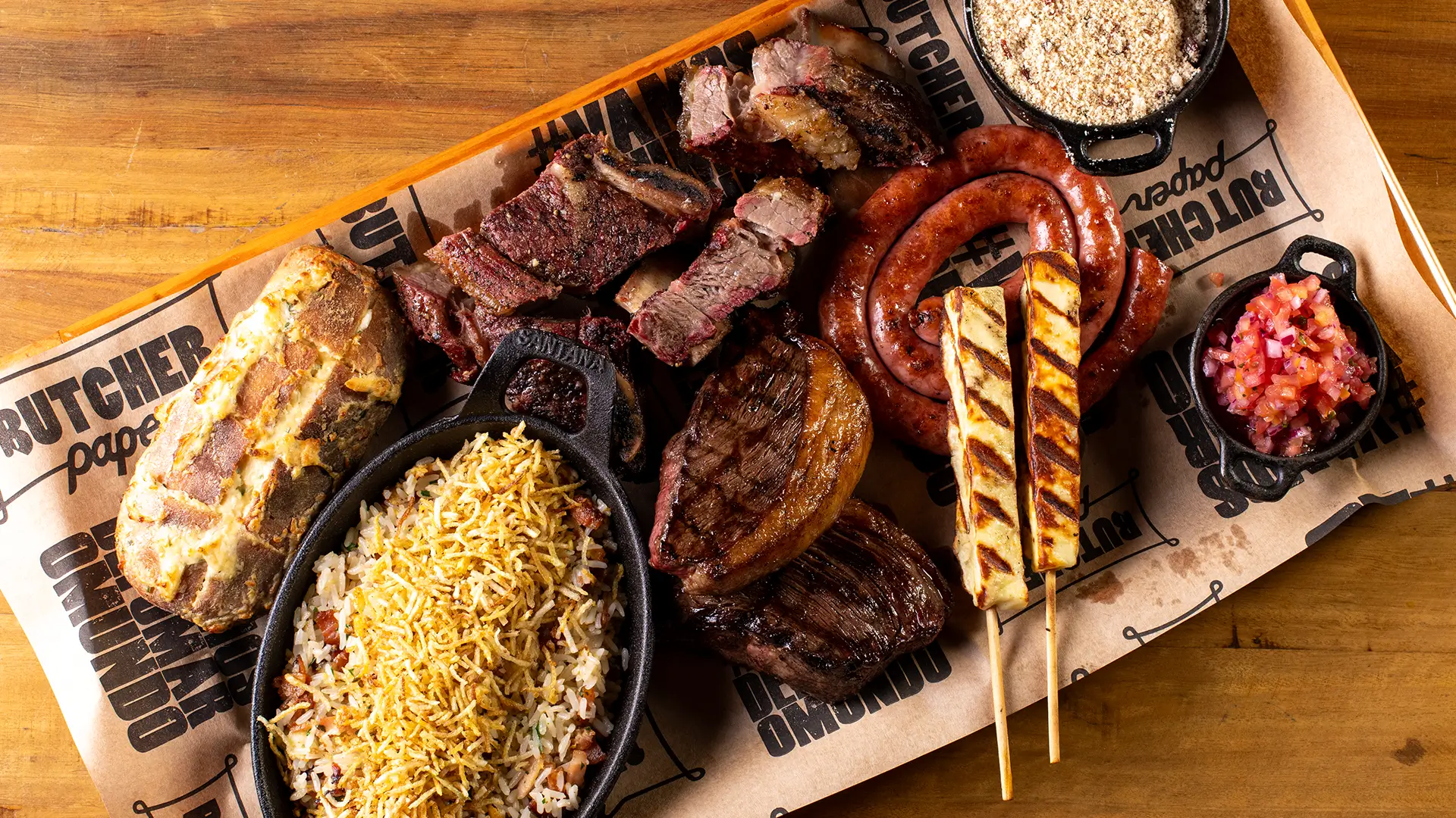 Tábua de churrasco completa Box Brazuca com costela assada, picanha, linguiça e acompanhamentos servida na Ramalho Experience, referência em costelaria Campinas.
