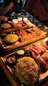 Tábuas com carnes nobres, batata palha e acompanhamentos servidos em uma confraternização de empresa no Ramalho Experience.