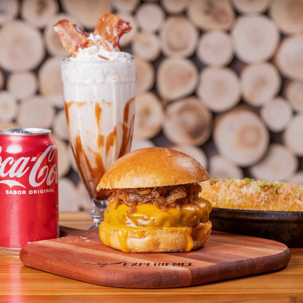 Cheeseburger com cebola caramelizada e milkshake de bacon na tábua da hamburgueria campinas Ramalho Experience.