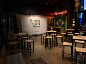Salão modular configurado para convenção corporativa no espaço para eventos em Campinas Ramalho Experience, com mesas bistrô altas, painel de backdrop e letreiro neon.